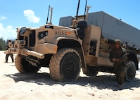 An artillery Marine from 1st Battalion, 12th Marines maneuvers a Navy/Marine Corps Expeditionary Ship Interdiction System launcher across the beach aboard Pacific Missile Range Facility Barking Sands, Hawaii, Aug. 16, 2021. During Large Scale Exercise 2021, the Marines of 1/12 struck a naval target ship with two Naval Strike Missiles which flew more than 100 nautical miles before striking the ship. The Marine Corps’ primary modernization priority in support of Force Design 2030 is fulfilling the requirement for a ground-based anti-ship missile capability. NMESIS is the Marine Corps’ first solution meeting this requirement. (U.S. Marine Corps photo by Cpl. Luke Cohen, released)