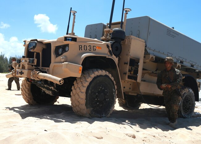 An artillery Marine from 1st Battalion, 12th Marines maneuvers a Navy/Marine Corps Expeditionary Ship Interdiction System launcher across the beach aboard Pacific Missile Range Facility Barking Sands, Hawaii, Aug. 16, 2021. During Large Scale Exercise 2021, the Marines of 1/12 struck a naval target ship with two Naval Strike Missiles which flew more than 100 nautical miles before striking the ship. The Marine Corps’ primary modernization priority in support of Force Design 2030 is fulfilling the requirement for a ground-based anti-ship missile capability. NMESIS is the Marine Corps’ first solution meeting this requirement. (U.S. Marine Corps photo by Cpl. Luke Cohen, released)