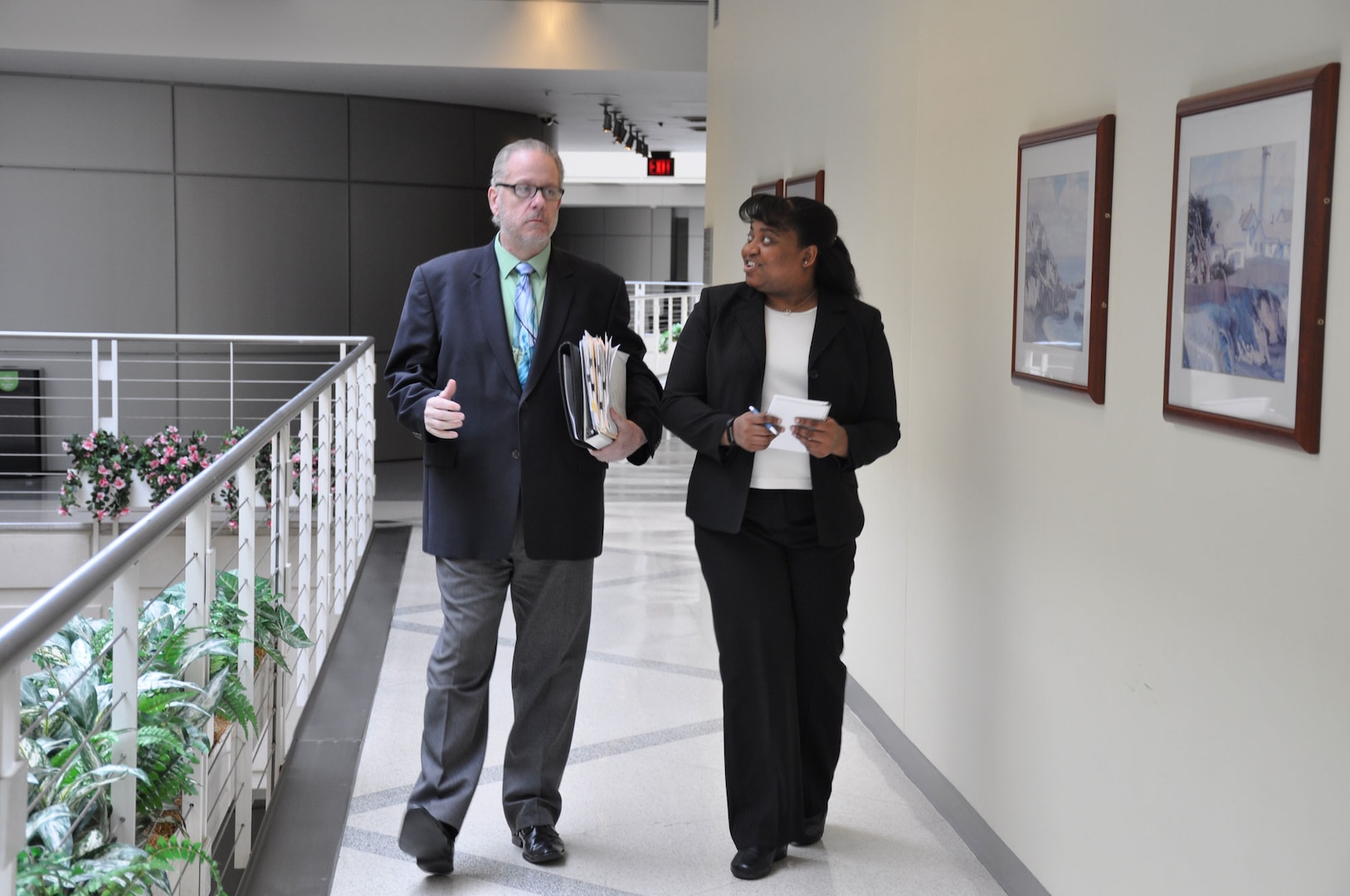 two people walking down a hallway