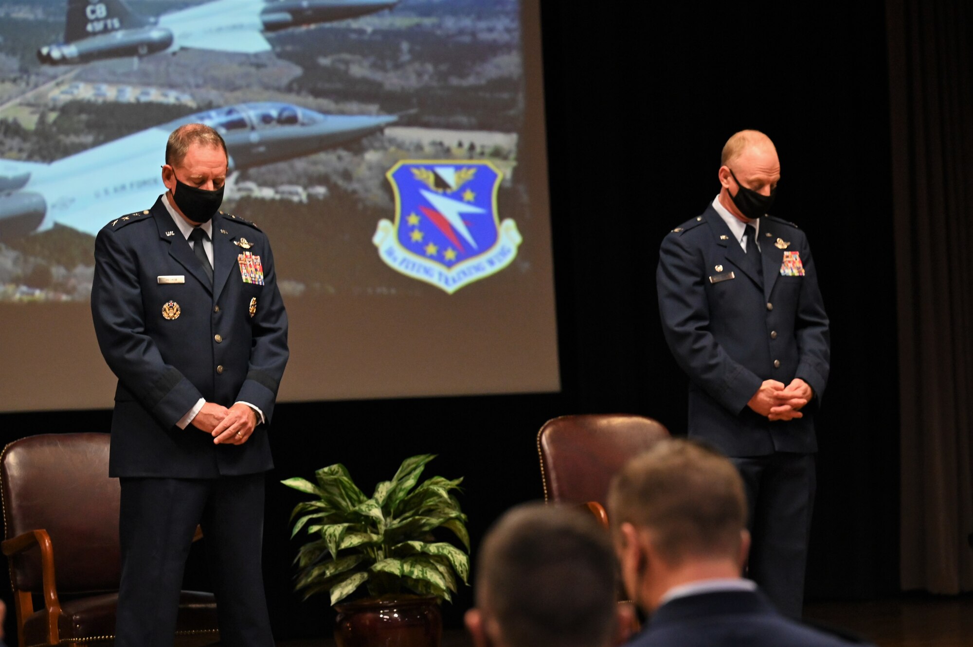 U.S. Air Force Lt. Gen. James Hecker, Air University Commander and President, and Col. Seth Graham, 14th Flying Training Wing Commander, bow their heads in prayer during the graduation ceremony of Specialized Undergraduate Pilot Training Class 21-15, Sept. 10, 2021, on Columbus Air Force Base, Miss. Hecker was commissioned in the Air Force in 1989 after graduating from the U.S. Air Force Academy and has commanded at the squadron, group, wing and numbered Air Force levels prior to his current position. (U.S. Air Force photo by Senior Airman Jake Jacobsen)