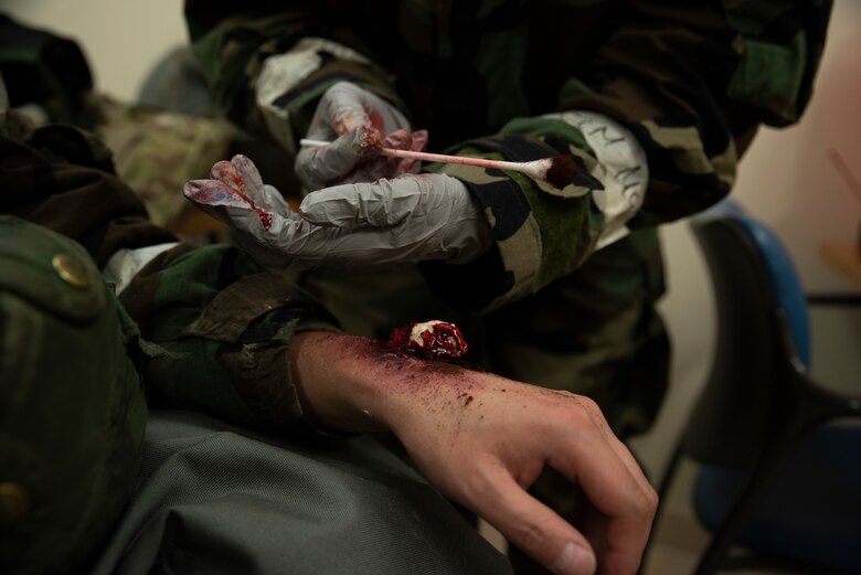 Senior Airman Kenyetta Oglesbe puts the finishing touches on a moulaged fractured wrist