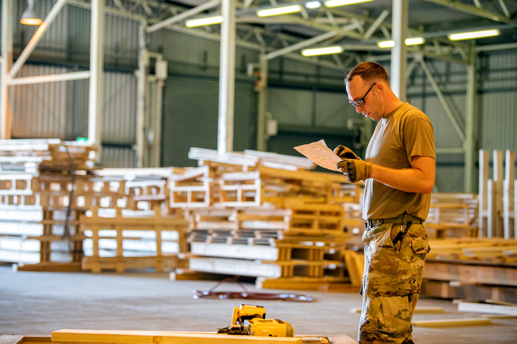 U.S. Air Force Tech. Sgt. Brandon Mullenix, 420th Munitions Squadron Conventional Maintenance Section Chief, reads a technical order at RAF Welford, England, Sept. 7, 2021. Airmen from the 420th MUNS constructed multiple wooden structures and supports to help stabilize inert assets to be transported to RAF Lakenheath for an upcoming Agile Combat Employment exercise. (U.S. Air Force photo by Senior Airman Eugene Oliver)