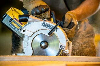 An Airman from the 420th Munitions Squadron cuts wood with an electrical saw at RAF Welford, England, Sept. 7, 2021. Airmen from the 420th MUNS constructed multiple wooden structures and supports to help stabilize inert assets to be transported to RAF Lakenheath for an upcoming Agile Combat Employment exercise. (U.S. Air Force photo by Senior Airman Eugene Oliver)