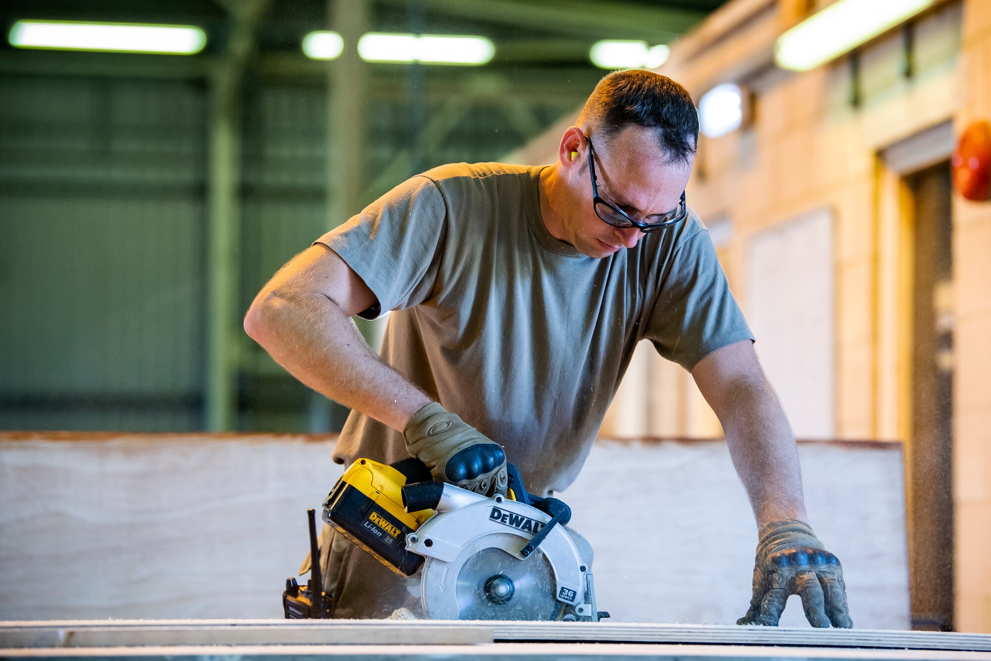 U.S. Air Force Tech. Sgt. Brandon Mullenix, 420th Munitions Squadron conventional maintenance section chief, cuts wood with an electrical saw prior to an asset transport at RAF Welford, England, Sept. 7, 2021. Airmen from the 420th MUNS constructed multiple wooden structures and supports to help stabilize inert assets to be transported to RAF Lakenheath for an upcoming Agile Combat Employment exercise. (U.S. Air Force photo by Senior Airman Eugene Oliver)