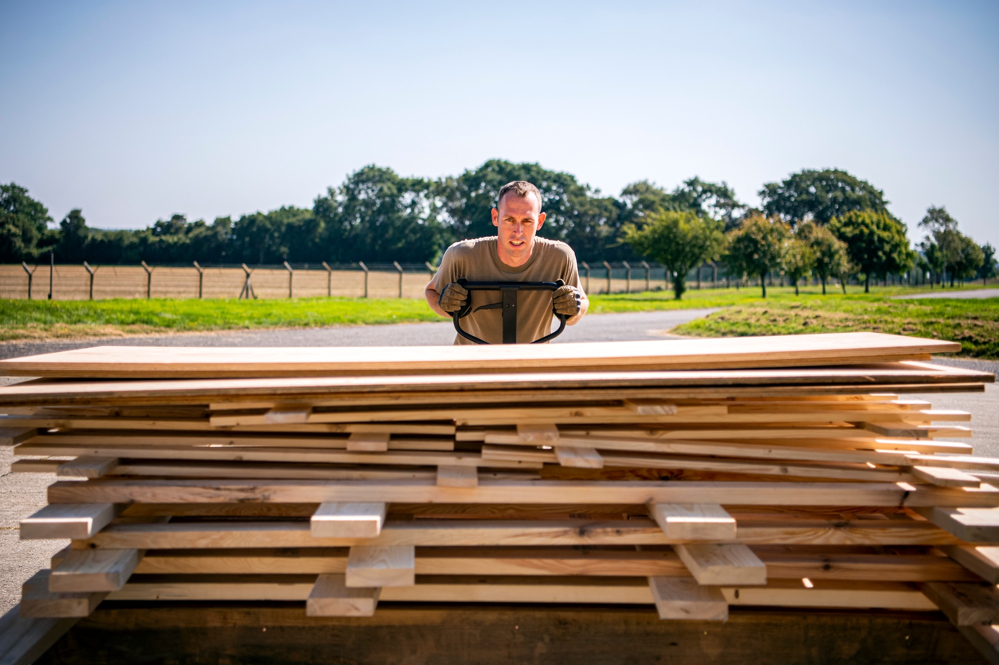 U.S. Air Force Tech. Sgt. Brandon Mullenix, 420th Munitions Squadron Conventional Maintenance Section Chief, moves wooden structures at RAF Welford, England, Sept. 7, 2021. Airmen from the 420th MUNS constructed multiple wooden structures and supports to help stabilize inert assets to be transported to RAF Lakenheath for an upcoming Agile Combat Employment exercise. (U.S. Air Force photo by Senior Airman Eugene Oliver)