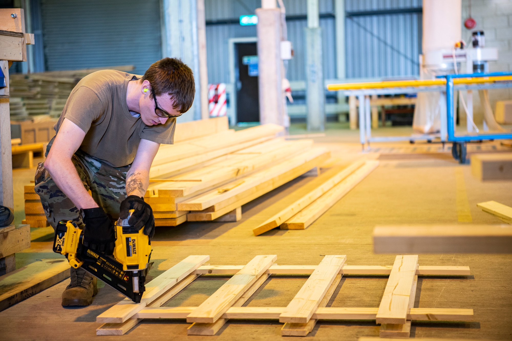 U.S. Air Force Airman 1st Class Caleb Wilson, 420th Munitions Squadron conventional maintenance technician, nails a wooden board into place at RAF Welford, England, Sept. 7, 2021. Airmen from the 420th MUNS constructed multiple wooden structures and supports to help stabilize inert assets to be transported to RAF Lakenheath for an upcoming Agile Combat Employment exercise. (U.S. Air Force photo by Senior Airman Eugene Oliver)