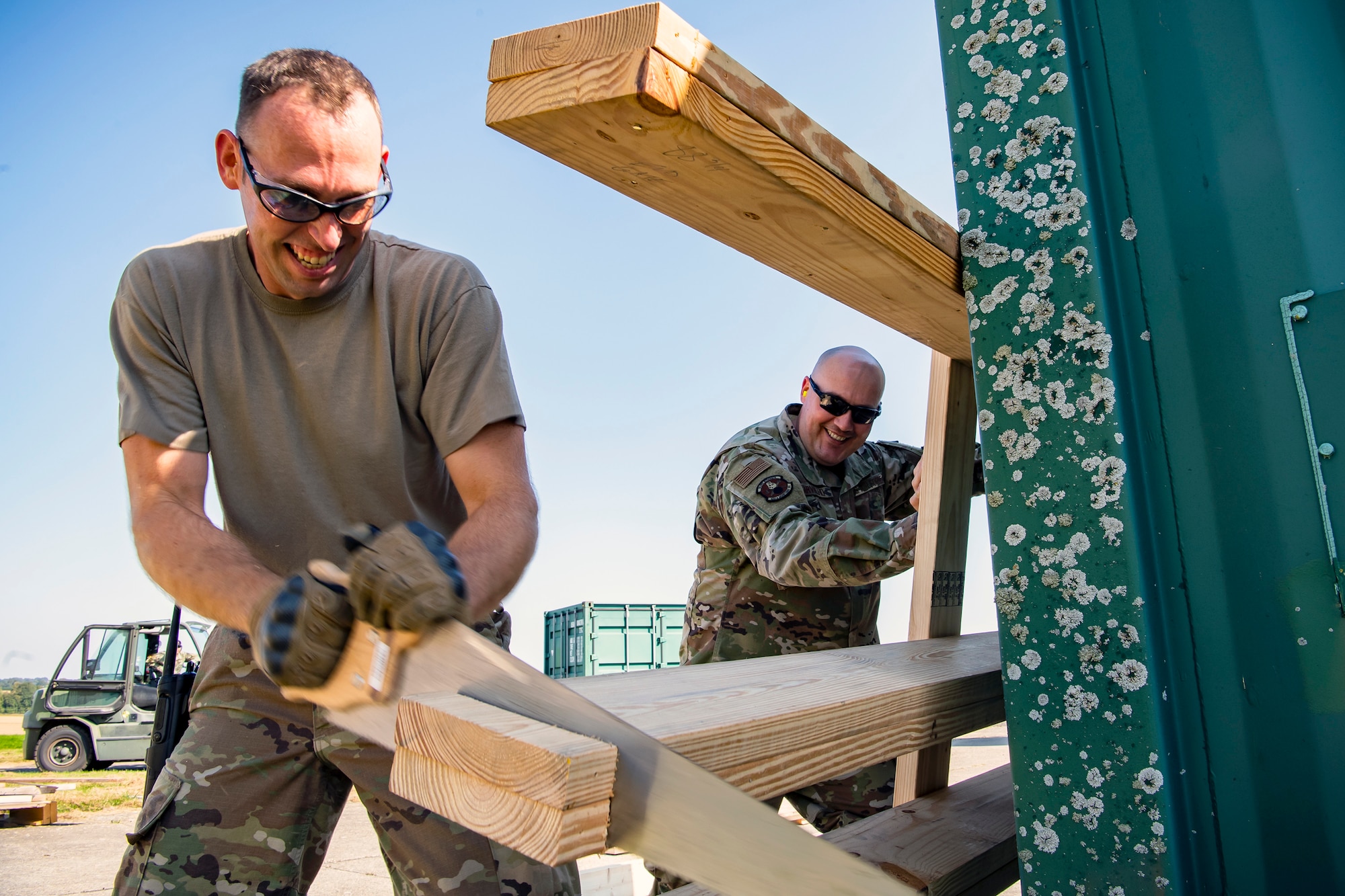 U.S. Air Force Tech. Sgt. Brandon Mullenix, 420th Munitions Squadron Conventional Maintenance Section Chief, cuts a piece of wood at RAF Welford, England, Sept. 7, 2021. Airmen from the 420th MUNS transported multiple inert assets to RAF Lakenheath for an upcoming Agile Combat Employment exercise. (U.S. Air Force photo by Senior Airman Eugene Oliver)