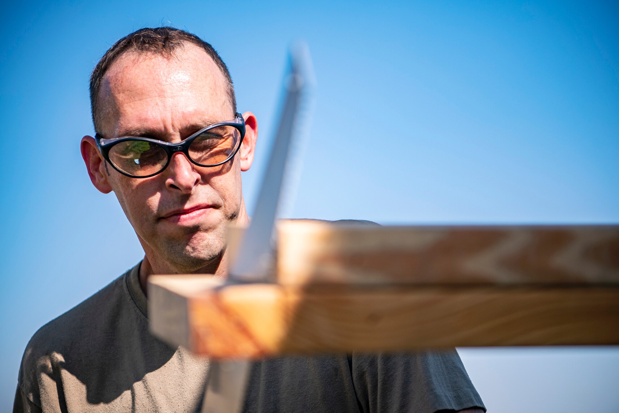 U.S. Air Force Tech. Sgt. Brandon Mullenix, 420th Munitions Squadron Conventional Maintenance Section Chief, cuts a piece of wood with a hand saw at RAF Welford, England, Sept. 7, 2021. Airmen from the 420th MUNS transported multiple inert assets to RAF Lakenheath for an upcoming Agile Combat Employment exercise. (U.S. Air Force photo by Senior Airman Eugene Oliver)