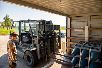 U.S. Air Force Senior Airman Von Mangaya, 420th Munitions Squadron stock pile technician, places inert assets inside an iso-container at RAF Welford, England, Sept. 7, 2021. Airmen from the 420th MUNS transported multiple inert assets to RAF Lakenheath for an upcoming Agile Combat Employment exercise. (U.S. Air Force photo by Senior Airman Eugene Oliver)