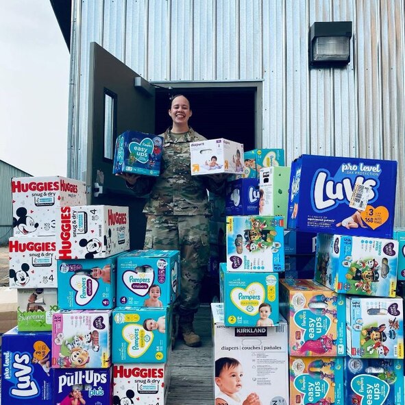 SSgt. Andrea Payne posing with the diapers she collected for the diaper drive.