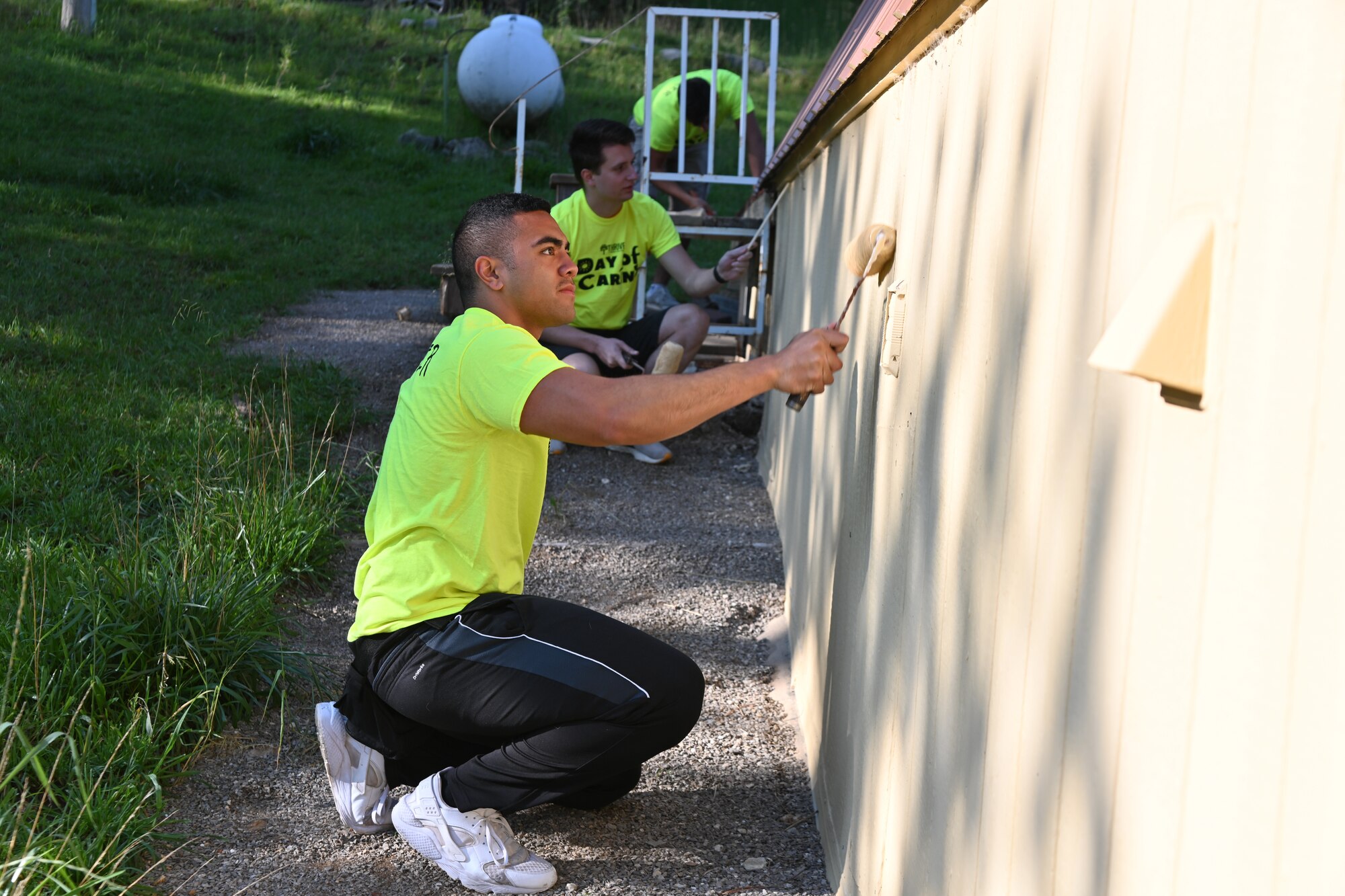 Senior Airman Ryan Lilomaiava, Day of Caring volunteer from Holloman Air Force Base, New Mexico, paints a house during the 30th annual Day of Caring, Sept. 10, 2021, in Cloudcroft, New Mexico. The Day of Caring offers support to families, disabled individuals and senior citizens within Otero County communities. (U.S. Air Force photo by Airman 1st Class Jessica Sanchez-Chen)
