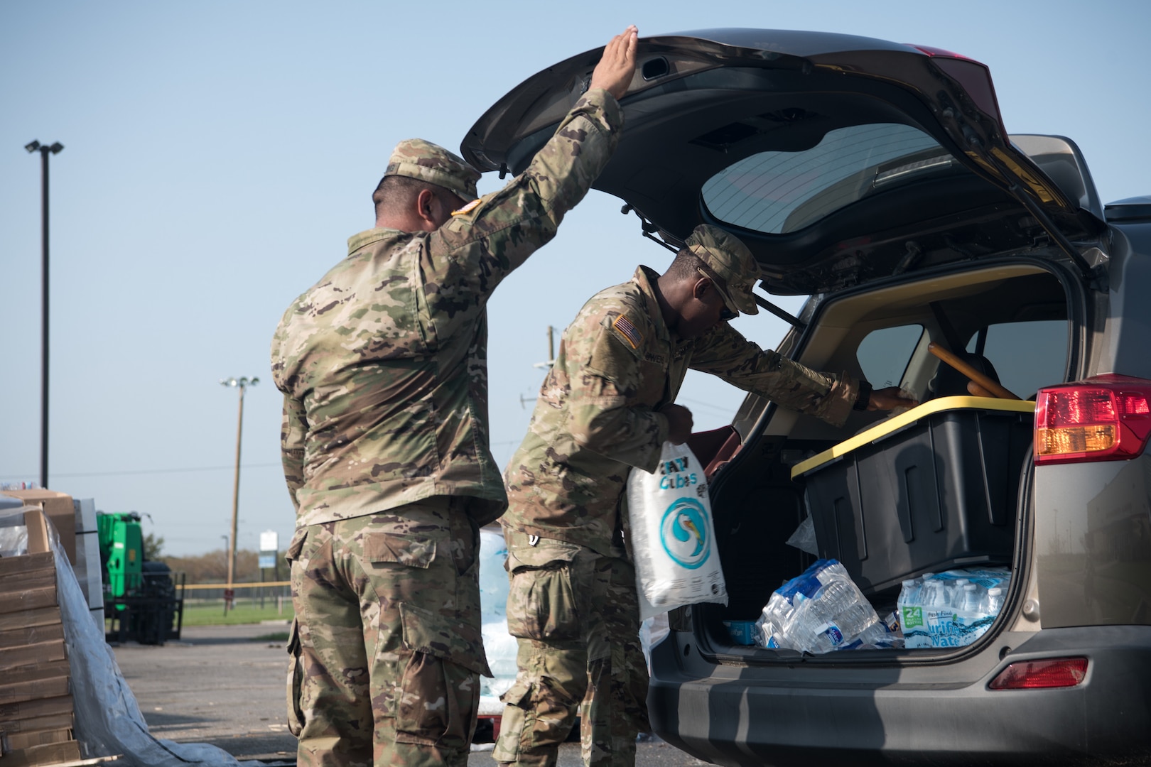 Sgt. 1st Class Charles Spalding (left), a platoon sergeant with the 3120th Engineer Company, and Spc. Terrelle Bowens (right), a signal support systems specialist with the 205th Signal Company, both members of the Oklahoma Army National Guard, distribute supplies to citizens at a point of distribution site in Reserve, Louisiana, Sept. 5, 2021. The Oklahoma National Guard is operating 13 PODs across seven parishes that supply local families with tarps, meals ready to eat, ice and water as part of Hurricane Ida relief efforts. (Oklahoma National Guard photo by Senior Airman Alex Kaelke)