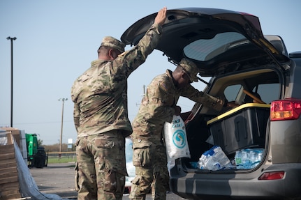 Sgt. 1st Class Charles Spalding (left), a platoon sergeant with the 3120th Engineer Company, and Spc. Terrelle Bowens (right), a signal support systems specialist with the 205th Signal Company, both members of the Oklahoma Army National Guard, distribute supplies to citizens at a point of distribution site in Reserve, Louisiana, Sept. 5, 2021. The Oklahoma National Guard is operating 13 PODs across seven parishes that supply local families with tarps, meals ready to eat, ice and water as part of Hurricane Ida relief efforts. (Oklahoma National Guard photo by Senior Airman Alex Kaelke)