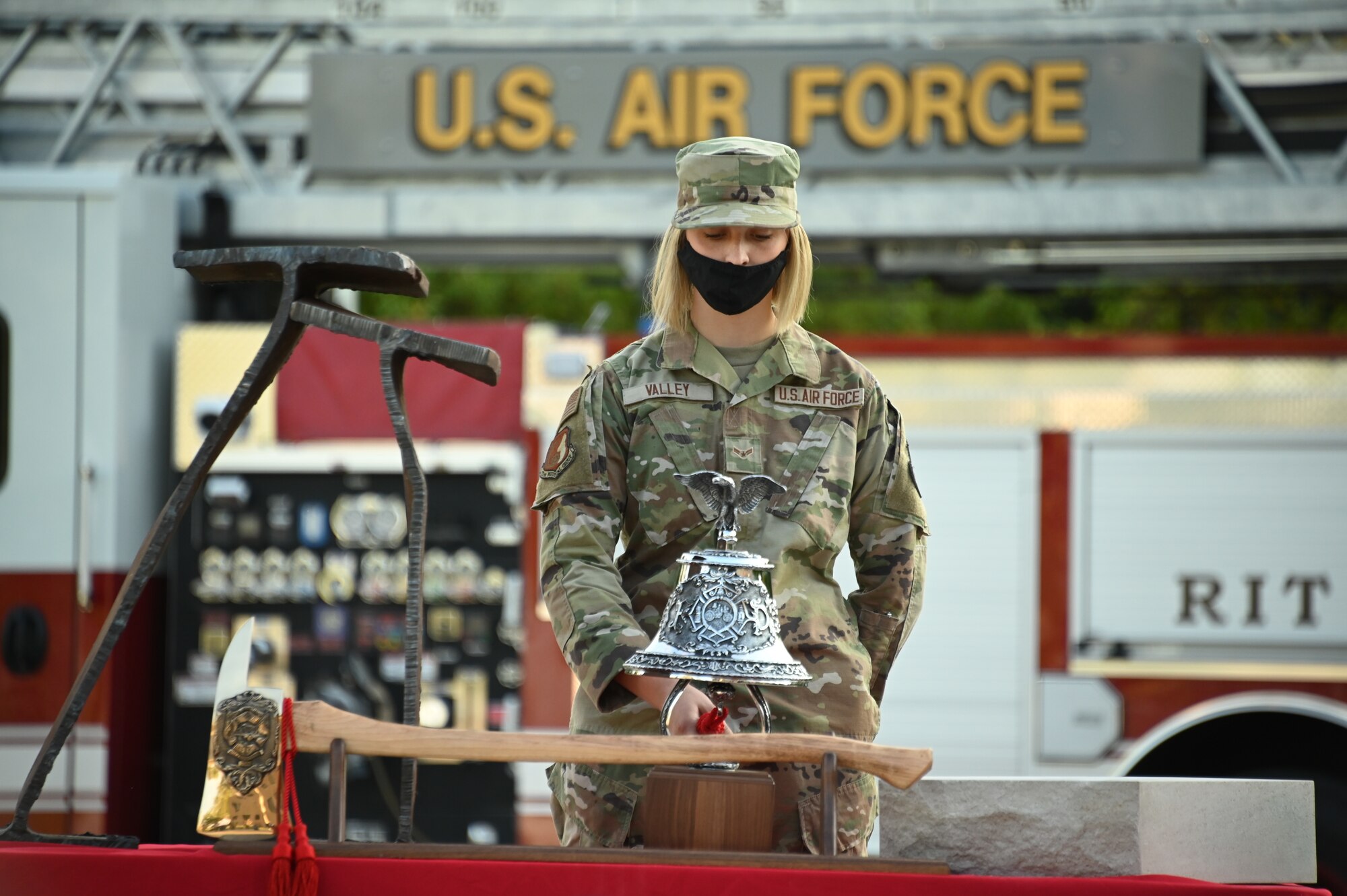 Airman 1st Class Ella Valley rings a ceremonial bell.