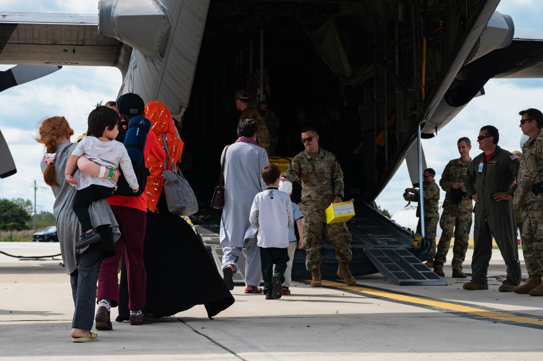 Groups of people board a military aircraft.