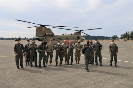 Members of the Royal Thai Army pose for a photo after a flight on a CH-47 Chinook helicopter Aug. 25, 2021 at Joint Base Lewis McChord, Washington state. The Thai Army aviators were taking part in a three-week aviation exchange with members of the Washington National Guard's 96th Aviation Troop Command.