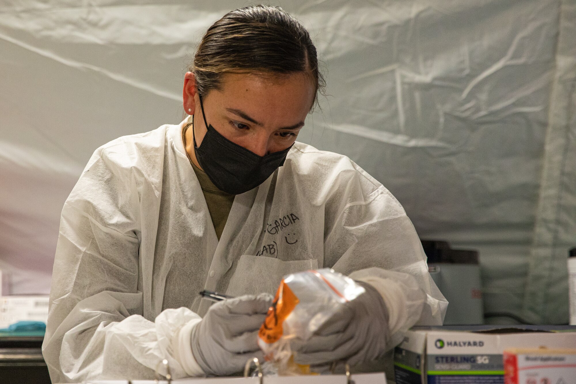 An Expeditionary Medical Support System Airman attached to Task Force-Holloman marks a urine sample in support of Operation Allies Welcome at Holloman Air Force Base, New Mexico, Sept. 10, 2021. The Department of Defense, through U.S. Northern Command, and in support of the Department of State and Department of Homeland Security, is providing transportation, temporary housing, medical screening, and general support for at least 50,000 Afghan evacuees at suitable facilities, in permanent or temporary structures, as quickly as possible. This initiative provides Afghan evacuees essential support at secure locations outside Afghanistan. (U.S. Army photo by Pfc. Anthony Sanchez)