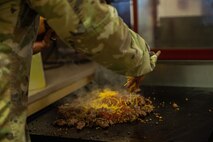 Senior Master Sgt. Aaron Waddy, Task Force-Holloman first sergeant, prepares breakfast for the Airmen working at Aman Omid Village in Holloman Air Force Base, New Mexico on Sept. 13, 2021. The Department of Defense, through U.S. Northern Command, and in support of the Department of State and Department of Homeland Security, is providing transportation, temporary housing, medical screening, and general support for at least 50,000 Afghan evacuees at suitable facilities, in permanent or temporary structures, as quickly as possible. This initiative provides Afghan evacuees essential support at secure locations outside Afghanistan. (U.S. Army photo by Pfc. Anthony Sanchez)
