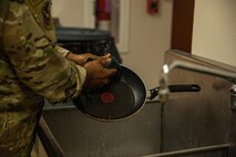 Lt. Col. Dwane Jones, Task Force-Holloman chaplain, cleans up after preparing breakfast for the Airmen working at Aman Omid Village in Holloman Air Force Base, New Mexico on Sept. 13, 2021. The Department of Defense, through U.S. Northern Command, and in support of the Department of State and Department of Homeland Security, is providing transportation, temporary housing, medical screening, and general support for at least 50,000 Afghan evacuees at suitable facilities, in permanent or temporary structures, as quickly as possible. This initiative provides Afghan evacuees essential support at secure locations outside Afghanistan. (U.S. Army photo by Pfc. Anthony Sanchez)