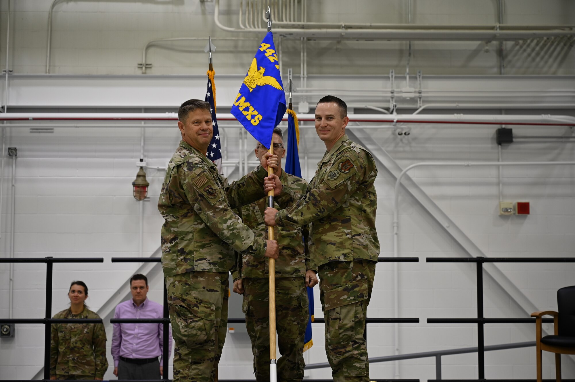 Lt. Col. William McLeod hands the 442 AMXS guidon to Maj. John Goodwin III while Erik stands at attention in civilian clothes in the background.
