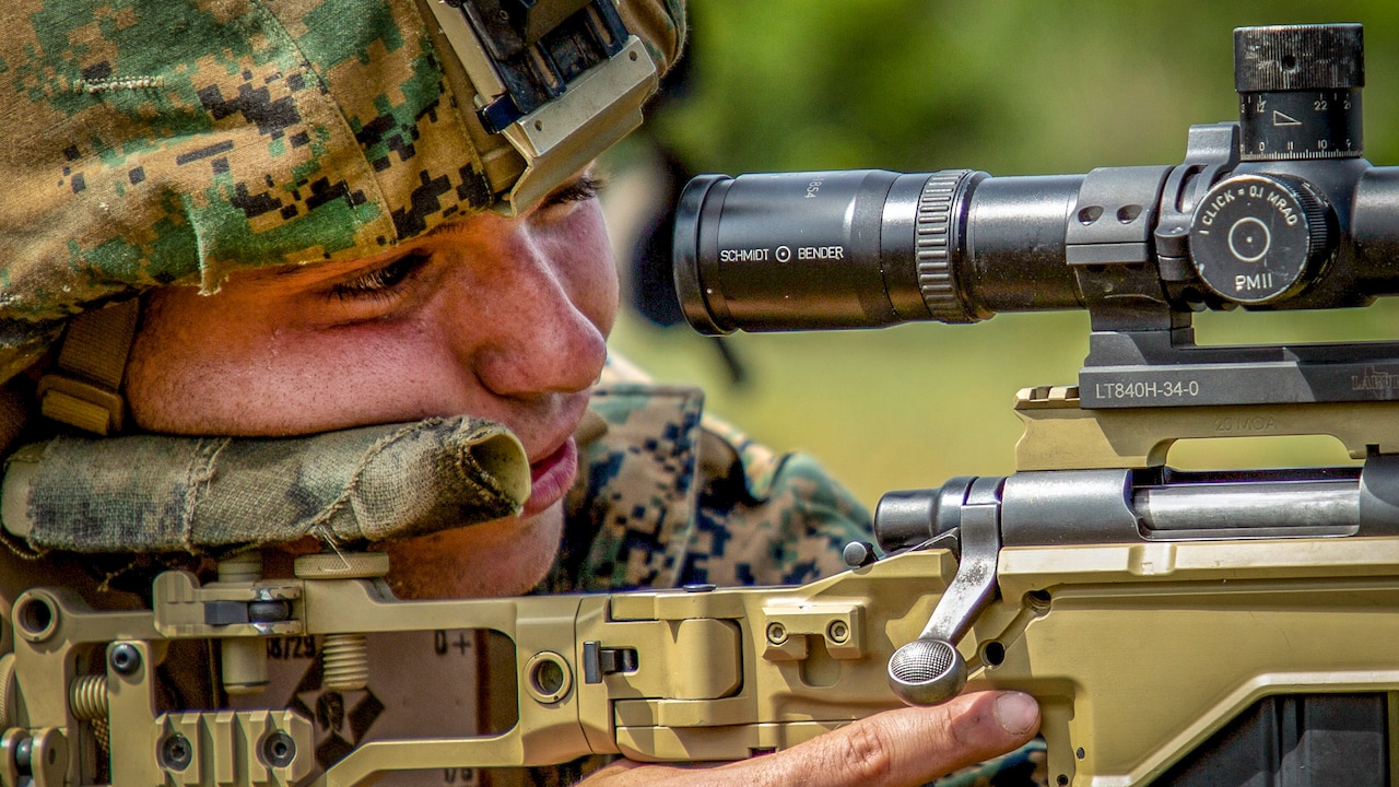 Marine looks through weapon scope.