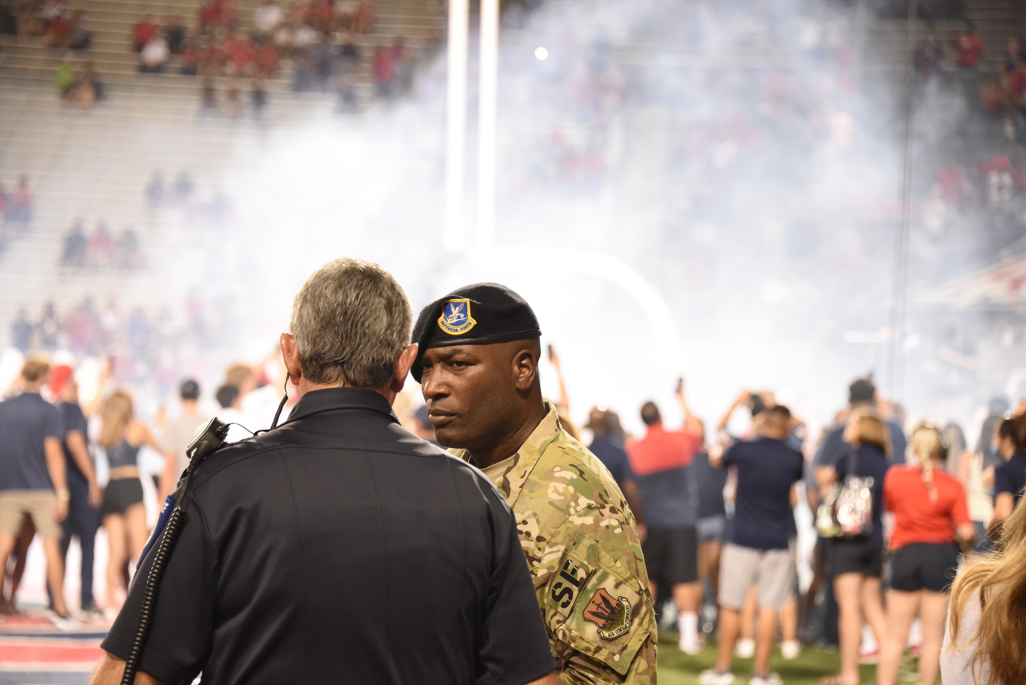 A photo of a military member talking to University of Arizona personnel.