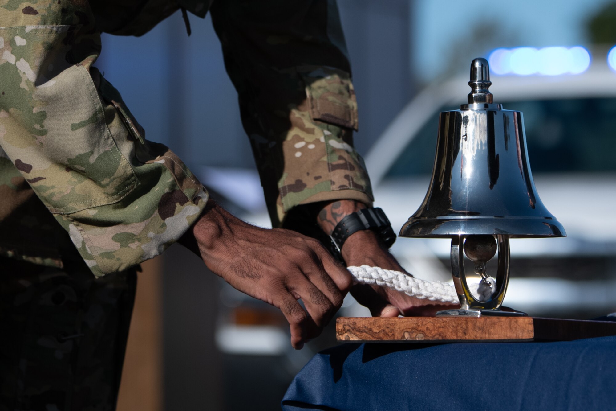 Airman ringing ceremonial bell