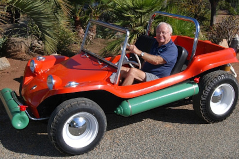 A man sits in a dune buggy.