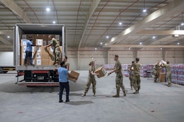Zack Bazzi, the regional director in the Middle East and Central Asia for the non-profit organization, Spirit of America, helps stack boxes of donated goods at Camp As Sayliyah, Qatar, September 5, 2021. Soldiers continue to support Department of Defense and Department of State teammates in Afghanistan evacuation efforts with care and compassion at various U.S. Central Command locations. (U.S. Army photo by Spc. Elizabeth Hackbarth, U.S. Army Central Public Affairs)