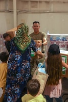 Zack Bazzi, the regional director in the Middle East and Central Asia for the non-profit organization, Spirit of America, helps stack boxes of donated goods at Camp As Sayliyah, Qatar, September 5, 2021. Soldiers continue to support Department of Defense and Department of State teammates in Afghanistan evacuation efforts with care and compassion at various U.S. Central Command locations. (U.S. Army photo by Spc. Elizabeth Hackbarth, U.S. Army Central Public Affairs)