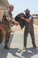 Zack Bazzi, the regional director in the Middle East and Central Asia for the non-profit organization, Spirit of America, helps stack boxes of donated goods at Camp As Sayliyah, Qatar, September 5, 2021. Soldiers continue to support Department of Defense and Department of State teammates in Afghanistan evacuation efforts with care and compassion at various U.S. Central Command locations. (U.S. Army photo by Spc. Elizabeth Hackbarth, U.S. Army Central Public Affairs)