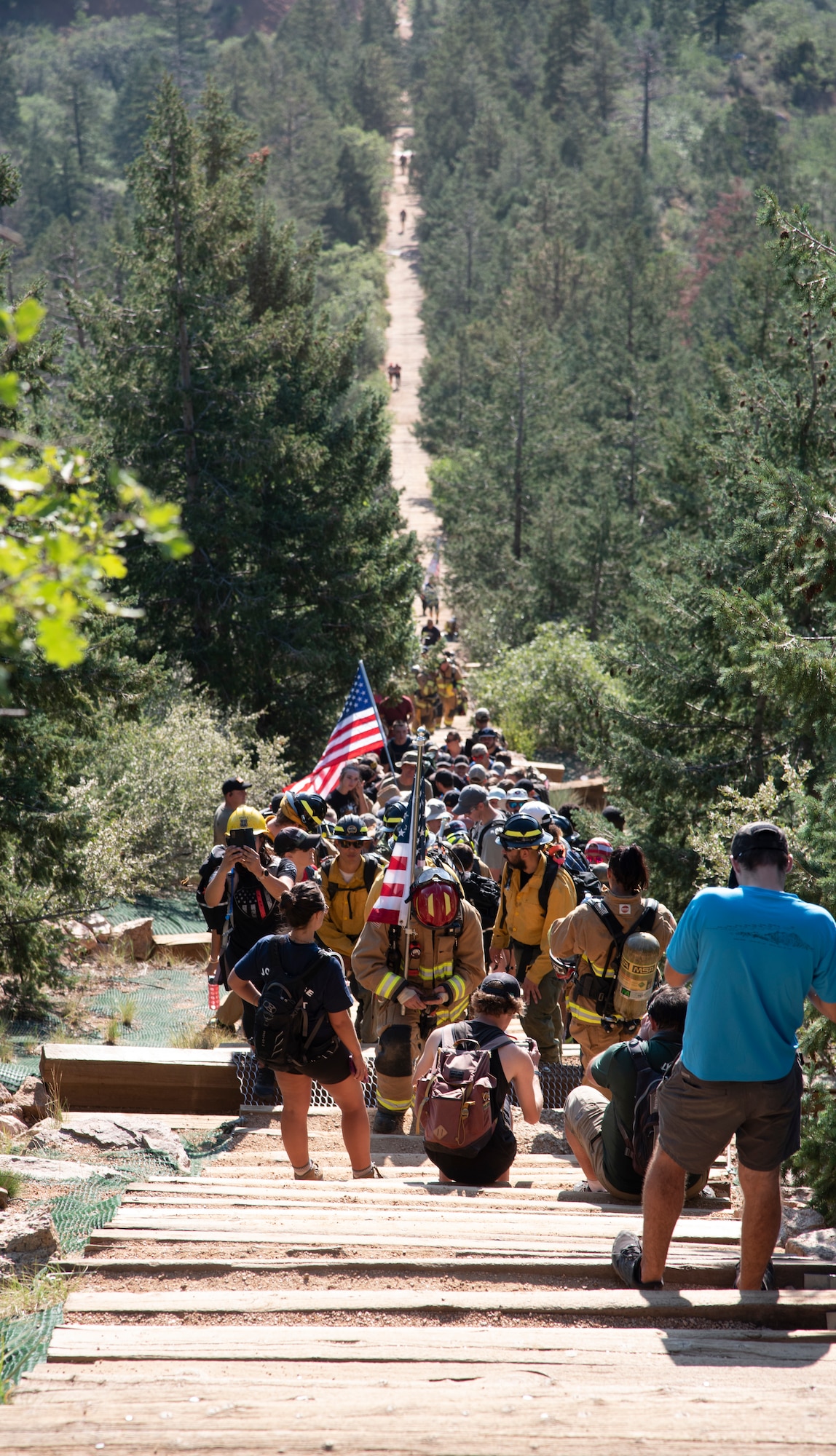 Firefighters from over 200 local and out-of-state fire stations kneel during a moment of silence while climbing up Manitou Incline.