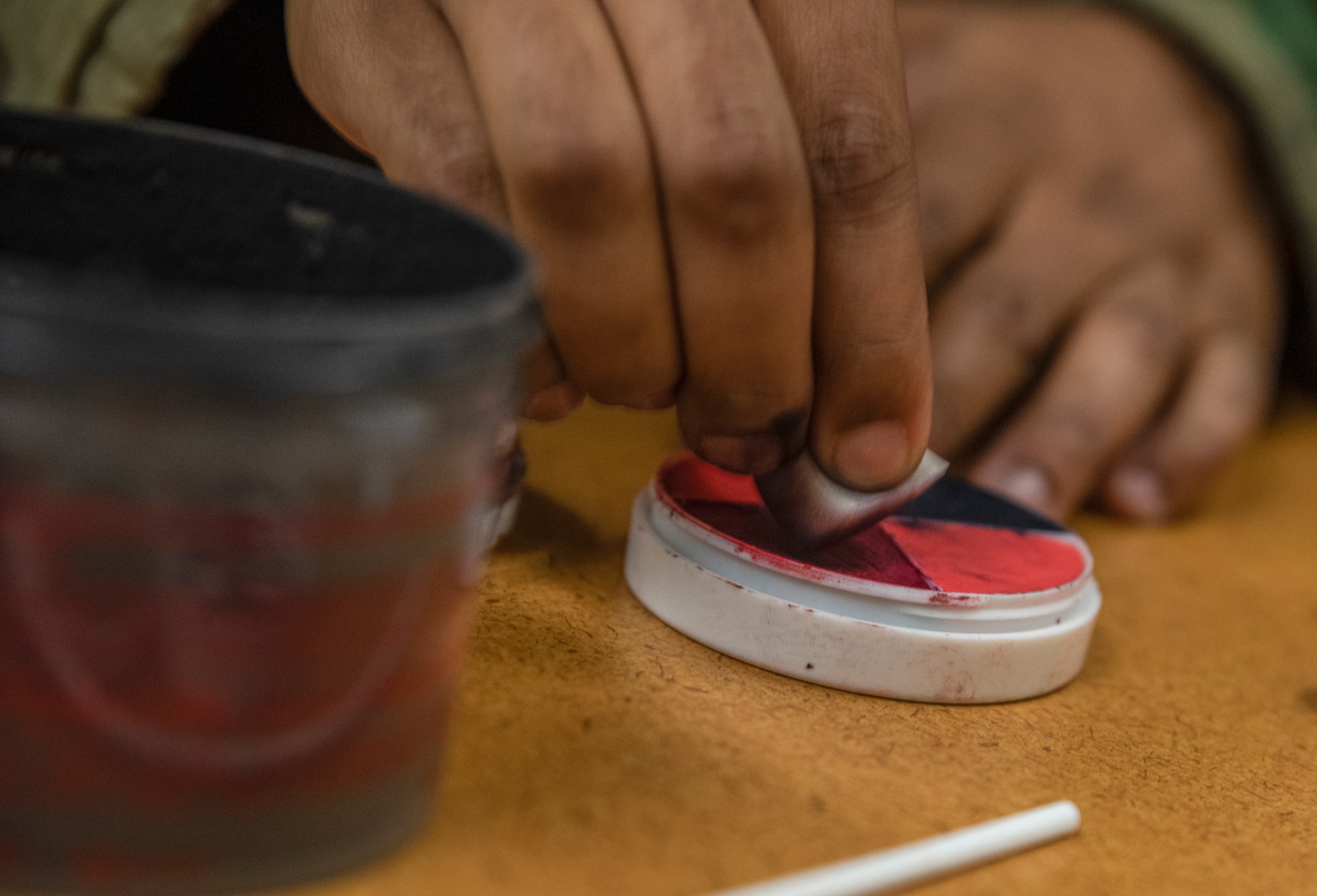 Staff Sgt Stephon Honeycutt prepares to apply makeup to a role player prior to a medical training scenario