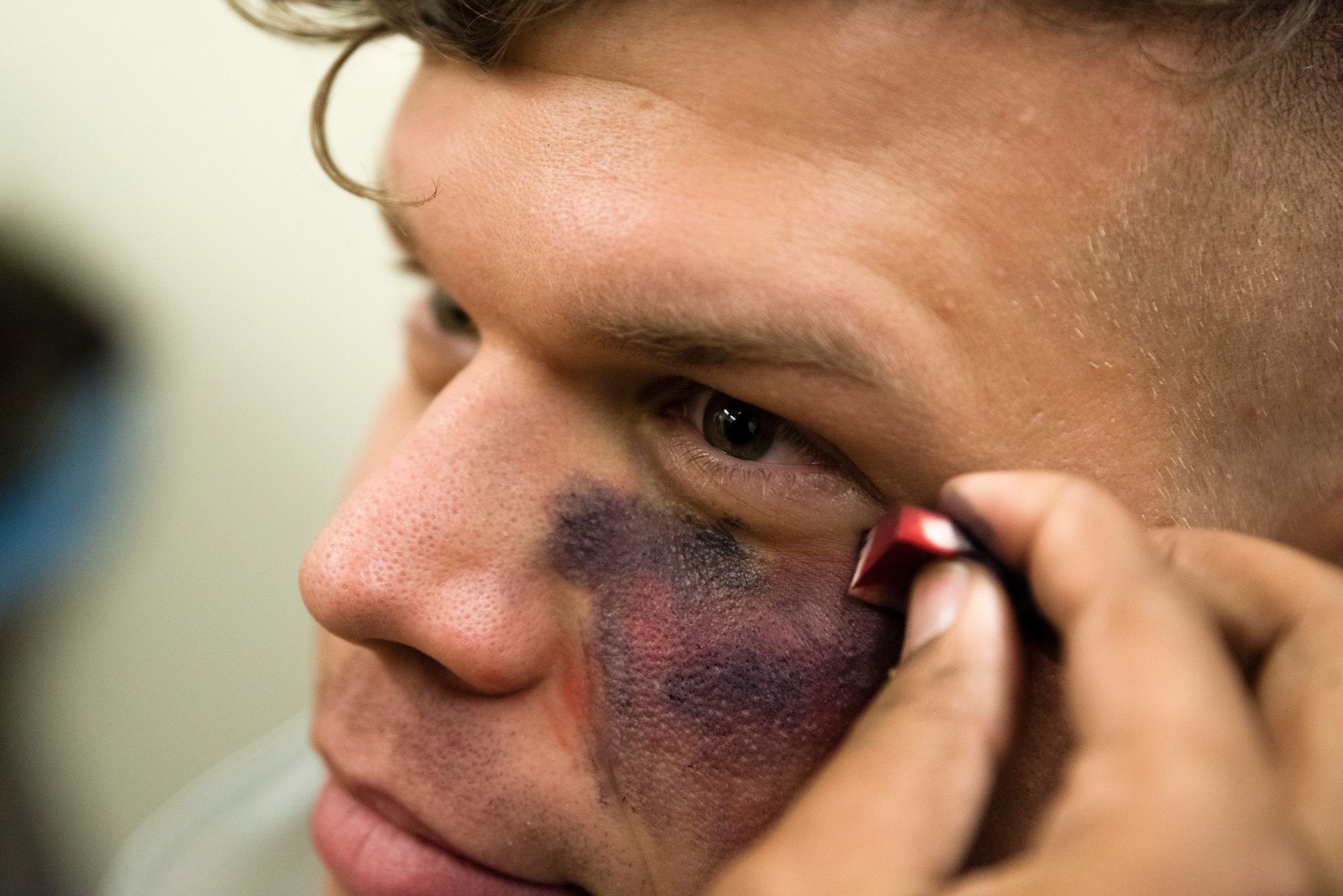 Staff Sgt. Bradley Borytsky has makeup applied to his head injury moulage prior to a training scenario