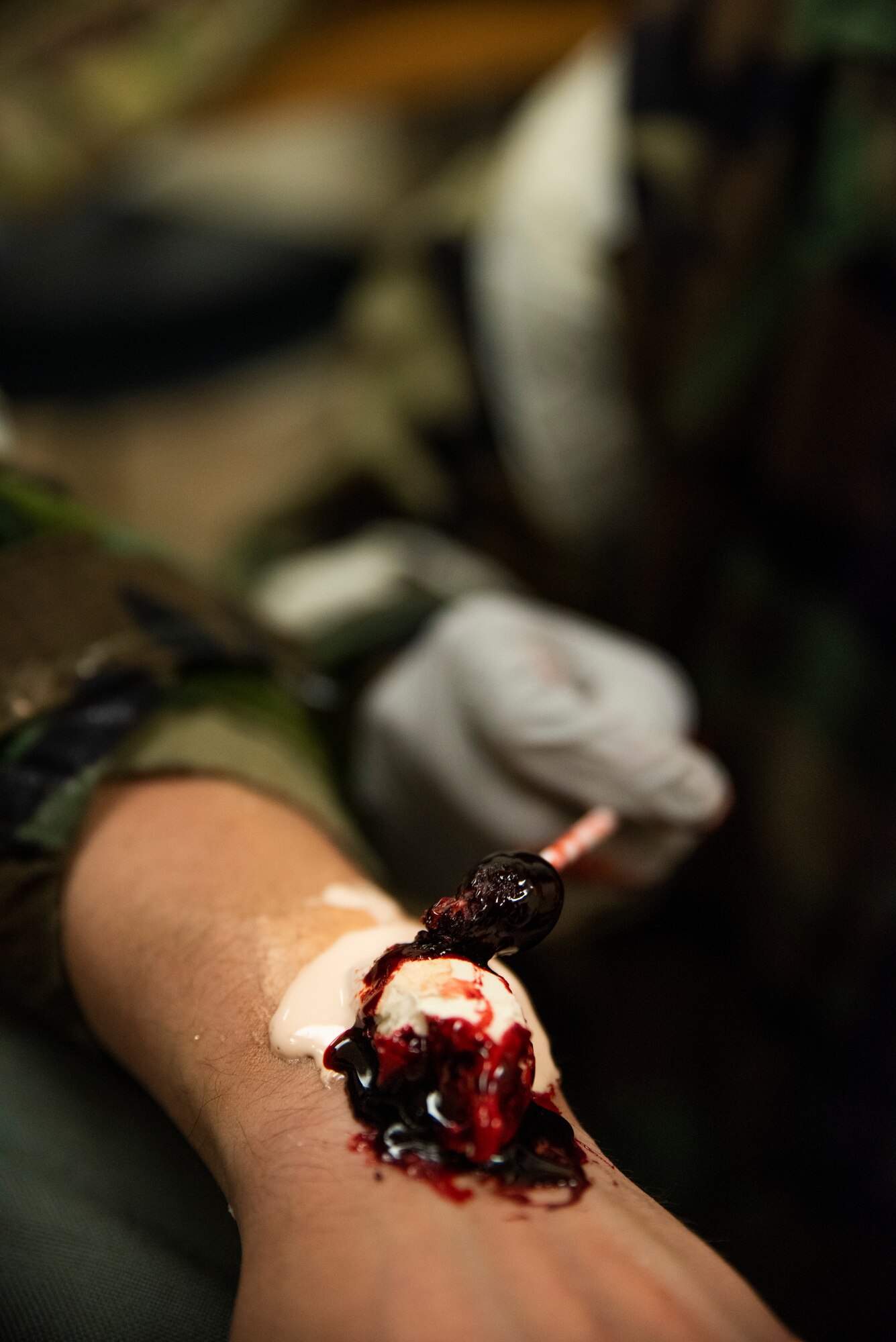 Senior Airman Kenyetta Oglesbe prepares a wrist fracture moulage for a member prior to a training scenario