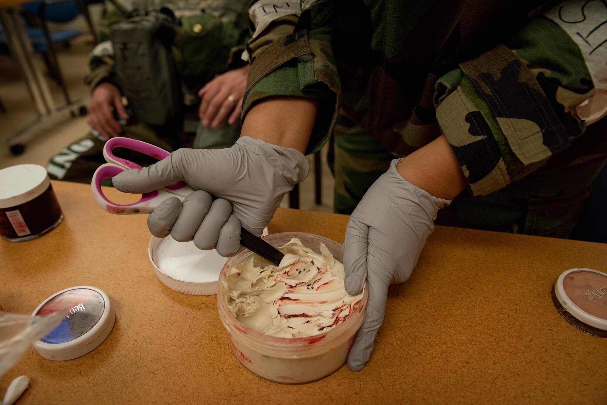 Senior Airman Kenyetta Oglesbe prepares putty to put on a moulage patient prior to a training scenario