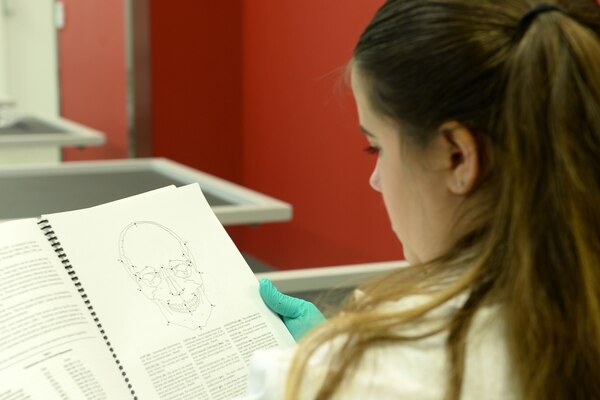 A woman looks at pages in a book.