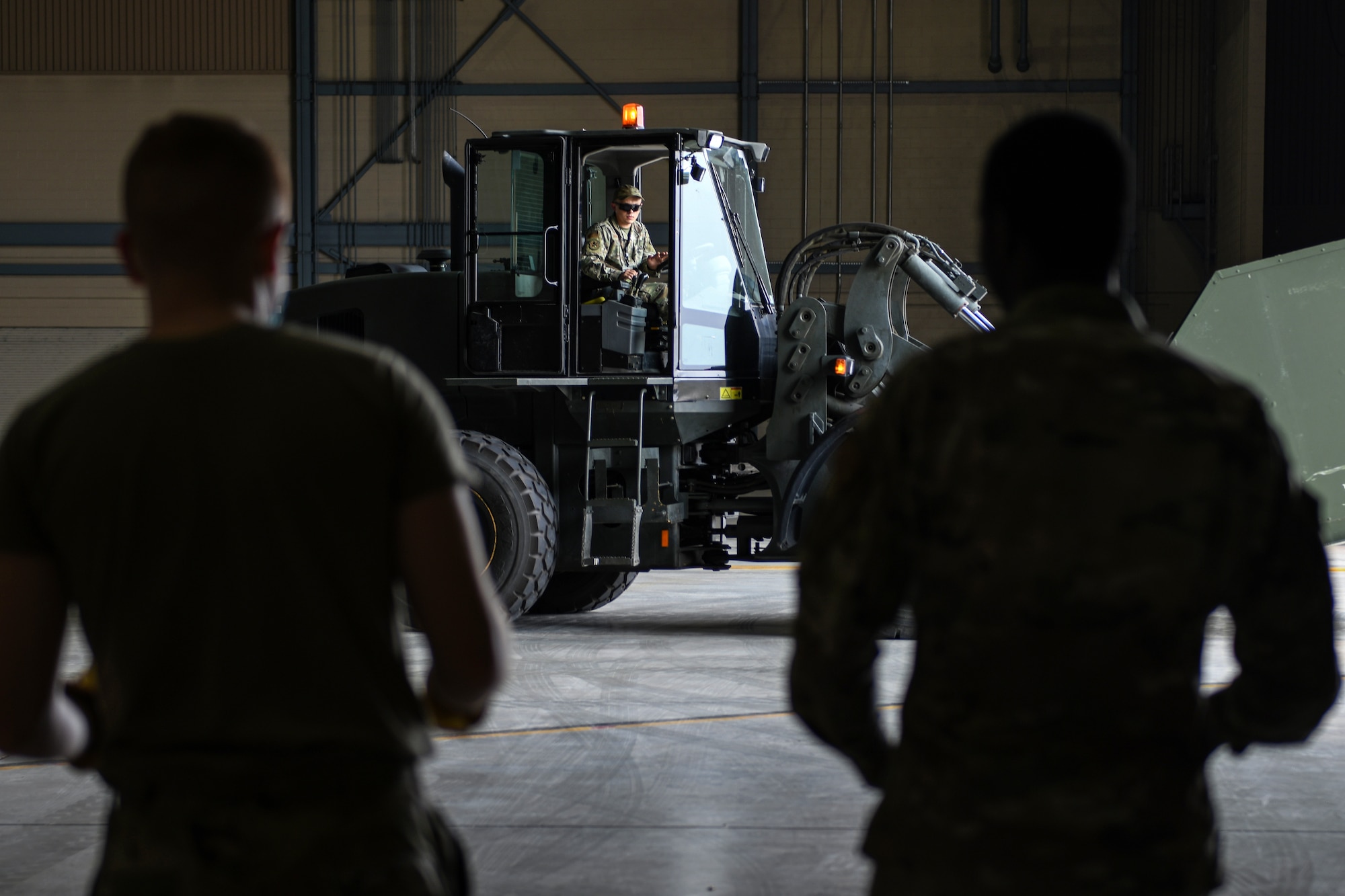 Airmen from the 319th Aircraft Maintenance Squadron watch as Staff Sgt. Thomas Anastasia, 319th Logistic Readiness Squadron vehicle operator, as he drives a forklift carrying equipment used during an exercise on Grand Forks Air Force Base, N.D., Aug. 18, 2021. A total of 768 items were transported throughout the exercise weighing in at approximately 153,884 pounds. (U.S. Air Force photo by Airman 1st Class Ashley Richards)