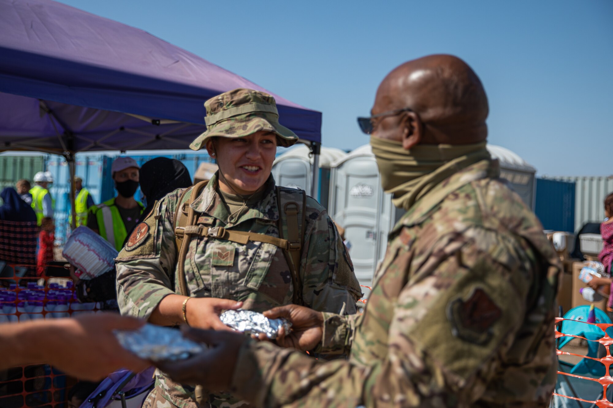 Lt. Col. Dwayne Jones, Task Force-Holloman chaplain, brings breakfast to Airmen working at Aman Omid Village in Holloman Air Force Base, New Mexico, Sept. 13, 2021. The Department of Defense, through U.S. Northern Command, and in support of the Department of State and Department of Homeland Security, is providing transportation, temporary housing, medical screening, and general support for at least 50,000 Afghan evacuees at suitable facilities, in permanent or temporary structures, as quickly as possible. This initiative provides Afghan evacuees essential support at secure locations outside Afghanistan. (U.S. Army photo by Pfc. Anthony Sanchez)