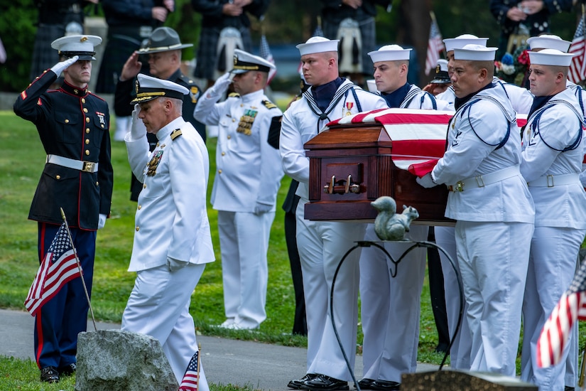 Sailors carry a flag-covered casket.
