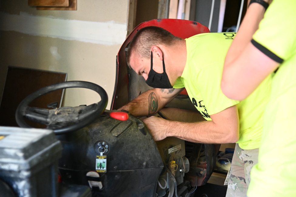 Tech. Sgt. Jacob McDevitt, Day of Caring volunteer from Holloman Air Force Base, New Mexico, repairs a broken lawn mower during the 30th Annual Day of Caring, Sept. 10, 2021, in Cloudcroft, New Mexico. Day of Caring brings together volunteers to complete pre-determined tasks for individuals who are either unable to accomplish the tasks themselves, or do not have the resources to do so. (U.S. Air Force Photo by Airman 1st Class Jessica Sanchez-Chen)