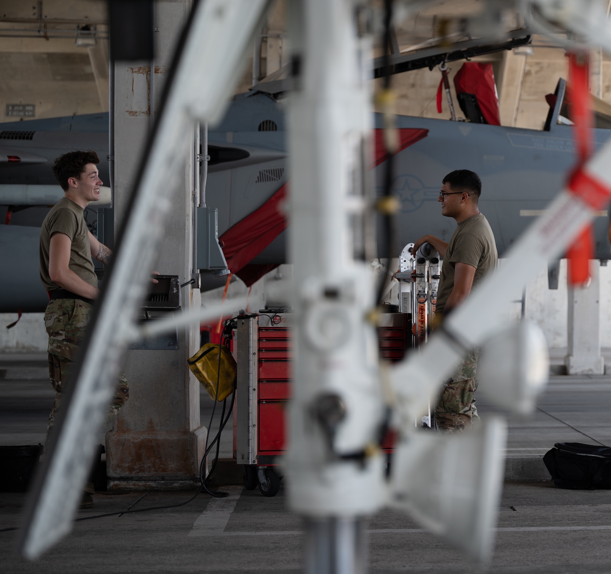 U.S. Air Force Airman 1st Class Zach Huschley, 67th Aircraft Maintenance Unit aerospace propulsion engineer, left, and U.S. Air Force Airman 1st Class Joel Hernandez, 67th AMU crew chief, right, hold a conversation at Kadena Air Base, Japan, Sept. 14, 2021. One mission of the 18th Wing is to deliver decisive airpower, any time, throughout the Indo-Pacific region. (U.S. Air Force photo by Airman 1st Class Stephen Pulter)