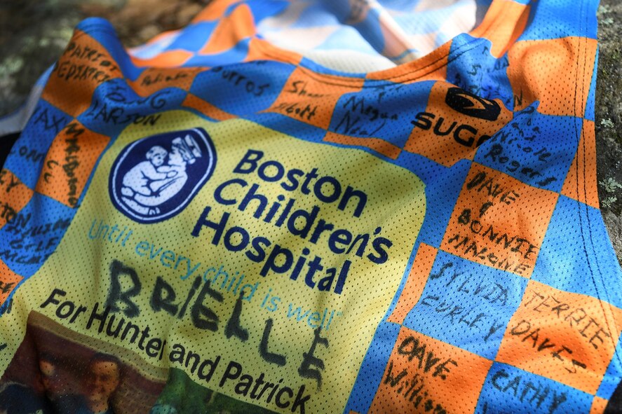 Sponsor signatures cover the Boston Marathon jersey front of Maj. Kristopher Williams, Kill Chain Integration Branch chief, outside Hanscom Air Force Base, Mass., Sept. 8. Williams will participate in the Oct. 11 race as part of the Boston Children’s Hospital marathon team, and will represent two child patients, Patrick, 15, from Burlington, Mass., and Hunter, 6, a Hanscom resident. (U.S. Air Force photo by Lauren Russell)
