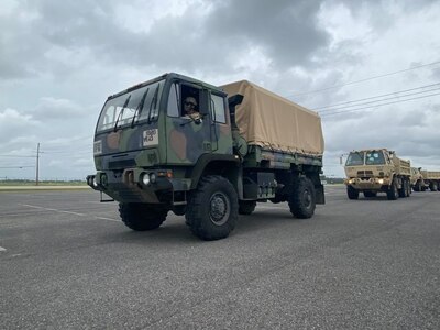 Light Medium Tactical Vehicles (LMTV) assigned to the Louisiana National Guard’s 527th Engineer Battalion, 225th Engineer Brigade, lead a convoy of dump trucks and flat-bottom boats to be staged in advance of Tropical Storm Nicholas at the Burton Coliseum in Lake Charles, Louisiana, Sept. 13, 2021.