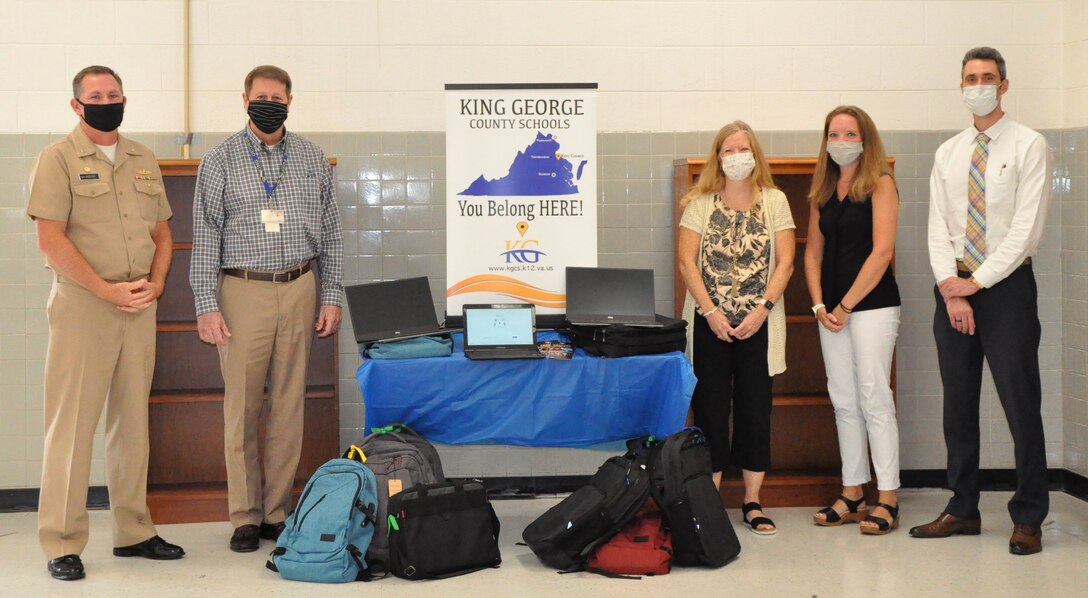 IMAGE: KING GEORGE, Va. – Naval Surface Warfare Center Dahlgren Division (NSWCDD) donates 10 laptop computers with carrying cases to King George County Public Schools. In attendance to present and receive the donation is NSWCDD Commanding officer Captain Stephen “Casey” Plew, Superintendent of King George County Schools Dr. Robert Benson, Supervisor of Curriculum and Instruction Kristine Hill, Supervisor of Technology Hillary Haff and NSWCDD Director of Collaborative Innovation Kyle Lackinger. (pictured left to right)