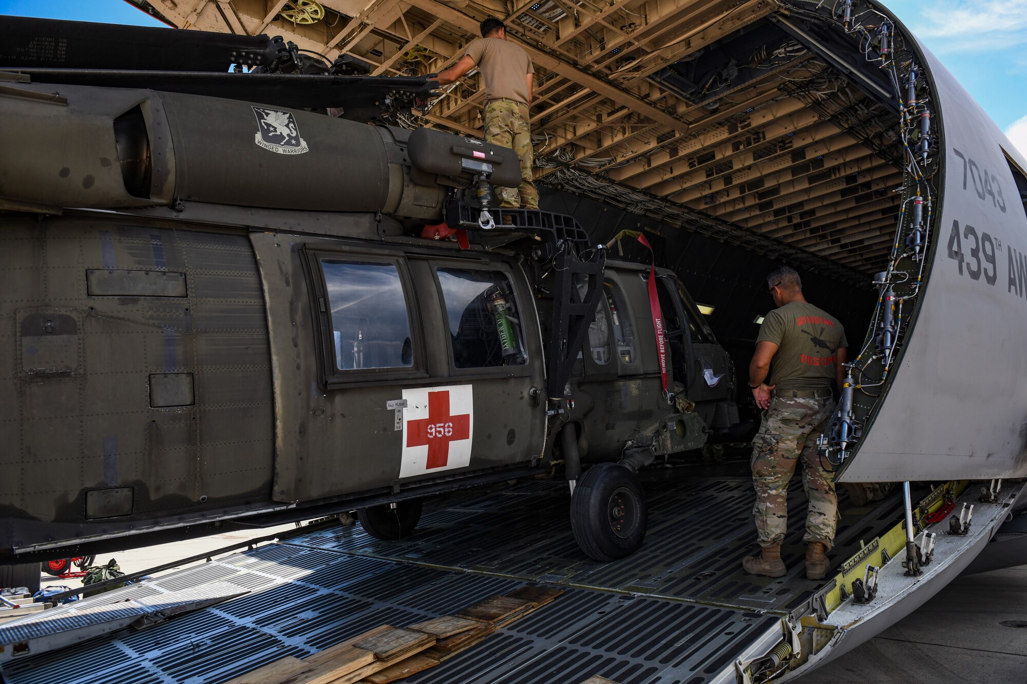Soldiers load an HH-60 Black Hawk helicopter into a C-5 Super Galaxy.