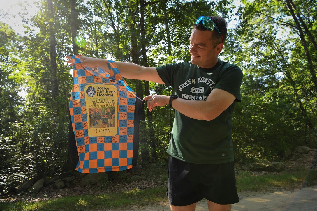 Maj. Kristopher Williams, Kill Chain Integration Branch chief, shows off the sponsor signatures on his Boston Marathon jersey while on a run outside Hanscom Air Force Base, Mass., Sept. 8. Williams will participate in the Oct. 11 race as part of the Boston Children’s Hospital marathon team, and will represent two child patients, Patrick, 15, from Burlington, Mass., and Hunter, 6, a Hanscom resident. (U.S. Air Force photo by Lauren Russell)