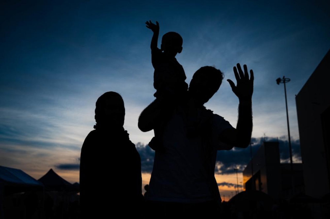A silhouette of two adults and a child.