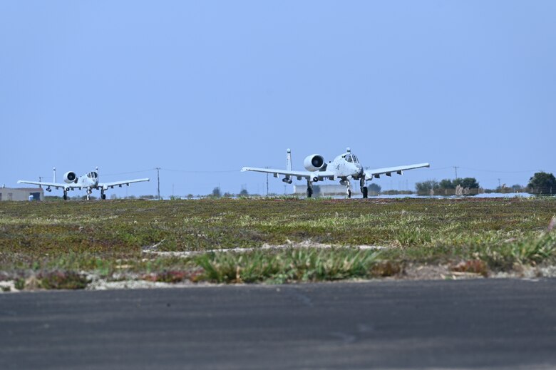 Two A-10 aircraft taxi on a runway