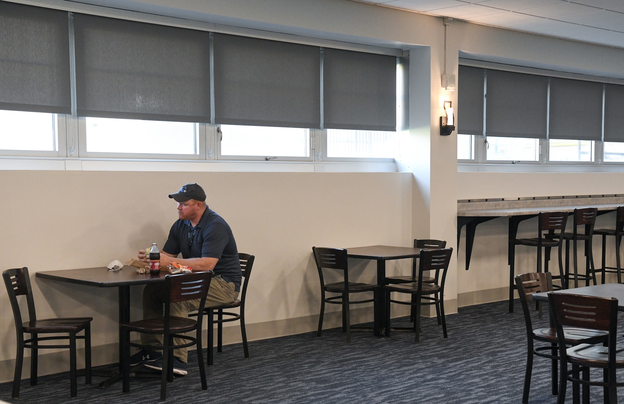Sterling Price, an Arnold Engineering Development Complex network engineer, dines in the newly-renovated Café 100, Sept. 9, 2021, at Arnold Air Force Base, Tenn. In the right of the photo, counter-height seating with electrical outlets for charging electronics can be seen, one of the additions made to the seating area. (U.S. Air Force photo by Jill Pickett)